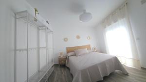 a white bedroom with a bed and a window at Casa Alba del Cabo in Los Albaricoques