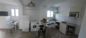 a white kitchen with a washing machine and a sink at Casa Alba del Cabo in Los Albaricoques