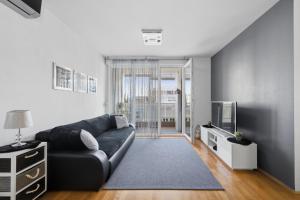 a living room with a black couch and a tv at Apartman Tonka in Šibenik