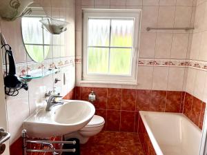 a bathroom with a sink and a toilet and a window at Gästehaus Helbighof in Neustadt an der Weinstraße +50 photos