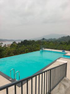 a large swimming pool with a view of a mountain at Nirvanica Retreat Wayanad in Padinjarathara