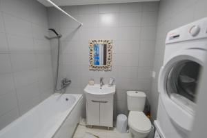 a bathroom with a toilet and a sink and a washing machine at Mark House 4 in Căuşeni +41 photos