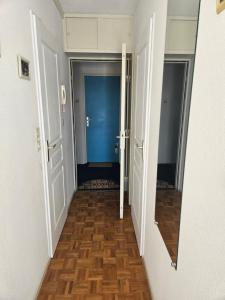 an empty hallway with two doors and a wooden floor at Port Dienville in Montfort-lʼAmaury