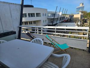 a table and chairs on a balcony with a boat at Port Dienville in Montfort-lʼAmaury