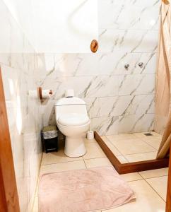 ein Badezimmer mit Toilette und Marmorwand in der Unterkunft Mindomundo Home in Mindo