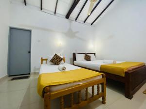 two beds sitting in a room with at Lakeside Haven Resort in Habarana +94 photos