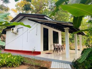 a small house with a patio and chairs at Lakeside Haven Resort in Habarana