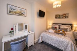 a small bedroom with a bed and a desk at Wallnook Cottage Luxury Yorkshire Escape in Lindley