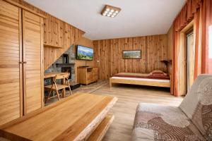 a bedroom with a bed and a table in a room at Domki - Pod Smerkami in Szklarska Poręba