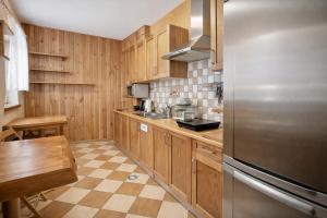 a kitchen with wooden cabinets and a stainless steel refrigerator at Domki - Pod Smerkami in Szklarska Poręba