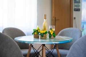a table with a bottle of wine and flowers on it at Apartments Ivo Bozinovic in Tivat