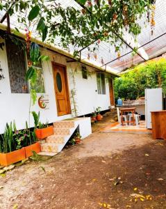 ein Haus mit einem Tisch und einer Bank davor in der Unterkunft Mindomundo Home in Mindo