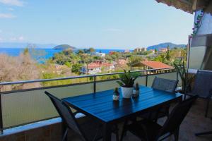 a blue table on a balcony with a view of the ocean at Riviera Penthouse in Paleo Tsifliki