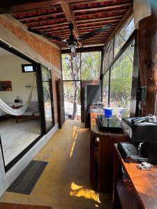 a room with large windows and a kitchen with a stove at Centro Sati Bungalow in Cuatunalco +117 photos