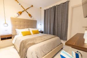 a bedroom with a large bed with yellow pillows at 2BDR Condo Beach Downtown Jacuzzi Pool Amenities in Cabo San Lucas