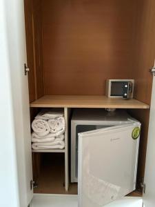 a small kitchen with a microwave and a refrigerator at Αφροδίτη Hotel in Néon Rýsion +40 photos