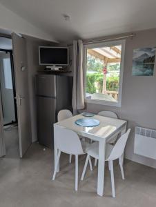 a small kitchen with a white table and chairs at Camping les charmettes in Les Mathes