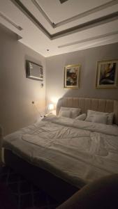 a bedroom with a large bed with a ceiling at ليالي القمر 2 in Sūq ath Thalut