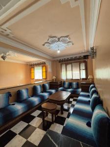 a waiting room with blue couches and a table at casa chawni in Chefchaouen