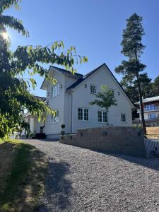 a white house with a stone driveway at Spacious, comfortable villa close to lake in Sigtuna