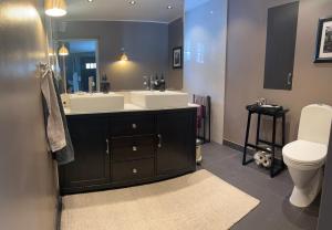 a bathroom with two sinks and a toilet and a mirror at Spacious, comfortable villa close to lake in Sigtuna +18 photos