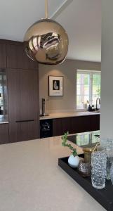 a kitchen with a table and a largeandelier at Spacious, comfortable villa close to lake in Sigtuna