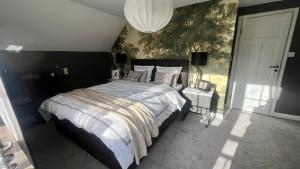 a bedroom with a large bed and a chandelier at Spacious, comfortable villa close to lake in Sigtuna