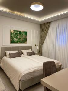a bedroom with a large bed and a table at Malka Suites in Beit Shemesh