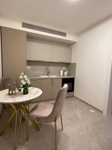 a kitchen with a table and chairs and a sink at Malka Suites in Beit Shemesh