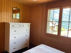 a bedroom with a white dresser and a window at Wohnung in Bergchalet in Flums