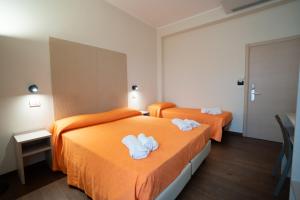 two beds in a hotel room with towels on them at Hotel Estense in Bellaria-Igea Marina +67 photos