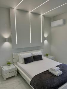 a bedroom with a large white bed with towels on it at Riviera Penthouse in Paleo Tsifliki