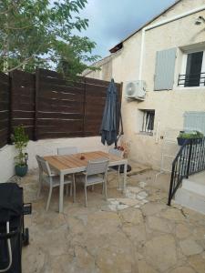 a table and chairs and an umbrella on a patio at Appartement dans la campagne in Le Beausset +2 photos