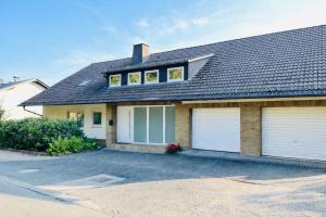 a house with two garage doors and a roof at Terrasse mit Ausblick in Biedenkopf