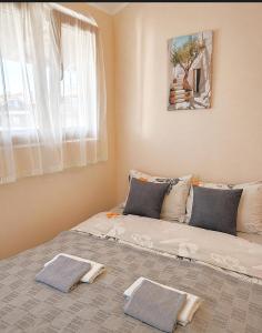 a bedroom with a bed with two towels on it at Gagin San -apartman na plaži in Veliko Gradište