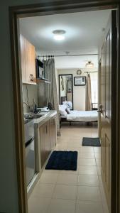 a kitchen with a sink and a room with a bed at Keyspace condotel in Piapi