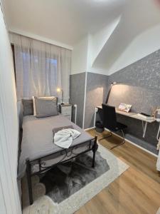 a bedroom with a bed and a desk with a computer at Chambres d'hotes la forêt in Longwy