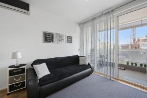 a black couch in a living room with a window at Apartman Tonka in Šibenik