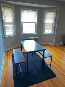 a room with a table and two chairs and two windows at Providence Cozy Stays in Providence