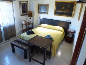 a small bedroom with a bed and a table at Sandra B&B in Luz de Tavira