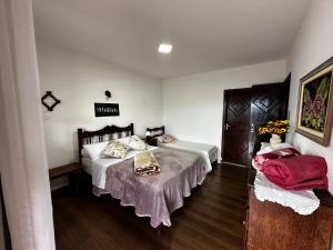 a bedroom with a bed and a table with pillows at Recanto Divô e Divó in Ouro Preto
