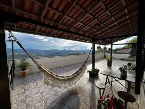 a hammock on a patio with a view of the mountains at Recanto Divô e Divó in Ouro Preto