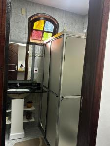 a bathroom with a refrigerator and a sink at Recanto Divô e Divó in Ouro Preto