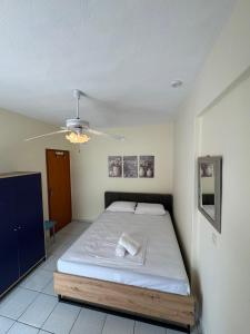 a bedroom with a bed and a ceiling fan at Eutopia stay in Flogita