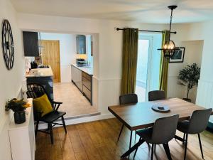 a dining room and kitchen with a table and chairs at Cockle Cottage in The Mumbles