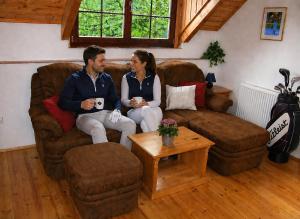 a man and a woman sitting on a couch at Penzion Vital in Liberec