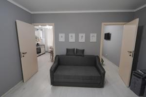 a living room with a couch and two open doors at Sânzâiana House 3 in Căuşeni
