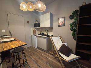 a kitchen with a table and a sink and a counter at Expérience Balinaise à Amiens in Amiens +10 photos