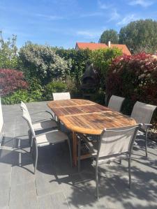 a wooden table and chairs on a patio at Au bon moment in Rang-du-Fliers