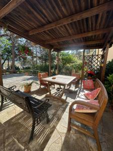 a patio with a table and chairs under a wooden pergola at Hotel La Pineta in Cogoleto